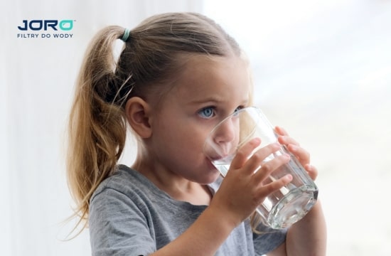 Dziewczynka pijąca czystą wodę z kranu – efekt działania filtrów i systemów uzdatniania wody marki Joro