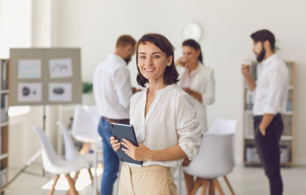 Uśmiechnięta konsultantka trzymająca tablet w biurze – doradztwo i sprzedaż filtrów do wody Joro dla domu i biznesu